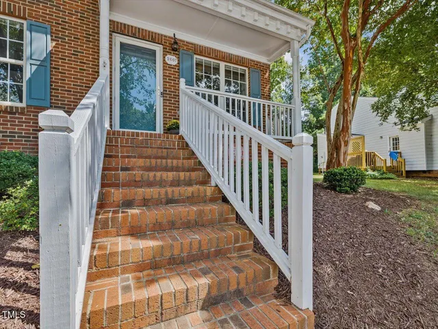 a view of a house with backyard and trees
