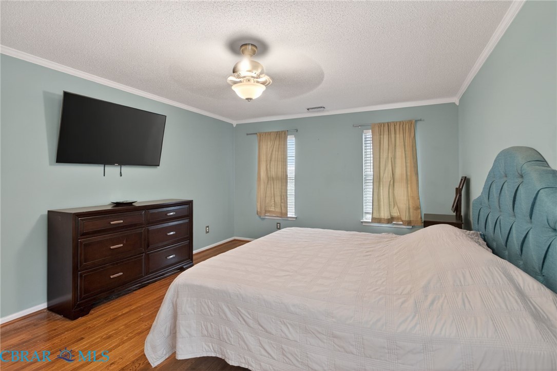 116 Old Field Road Williamsburg, VA 23188 - Photo 19 of 27 Bedroom with ornamental molding, dark wood-style floors, a textured ceiling, and ceiling fan
