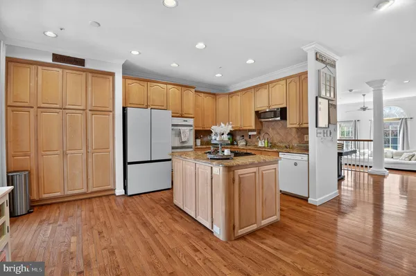 a kitchen with stainless steel appliances granite countertop a refrigerator stove and wooden cabinets