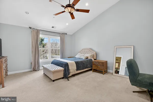 a spacious bedroom with a bed and a chandelier
