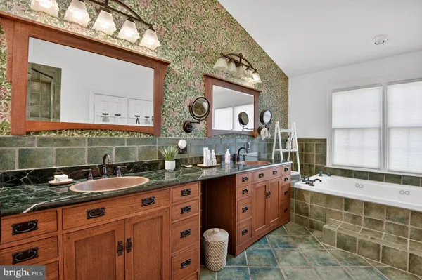 a bathroom with a granite countertop double vanity sink and mirror