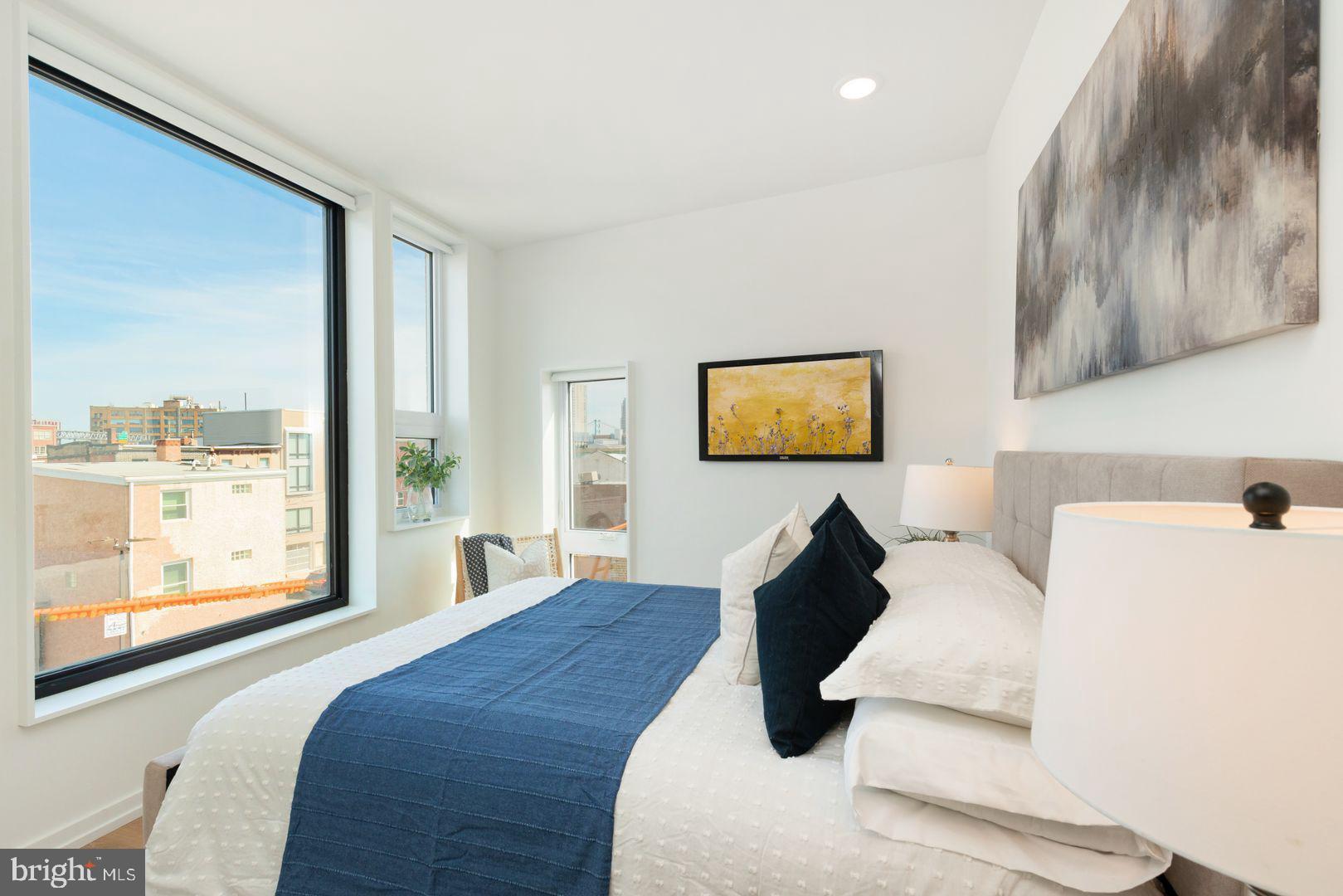 1141 North Front Street, Unit 307 Philadelphia, PA 19123 - Photo 14 of 28 a bedroom with a large bed and a large window