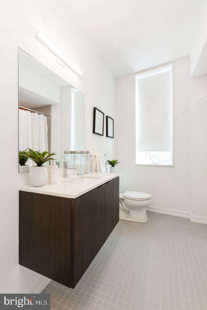 1141 North Front Street, Unit 307 Philadelphia, PA 19123 - Photo 15 of 28 a bathroom with a sink toilet and mirror