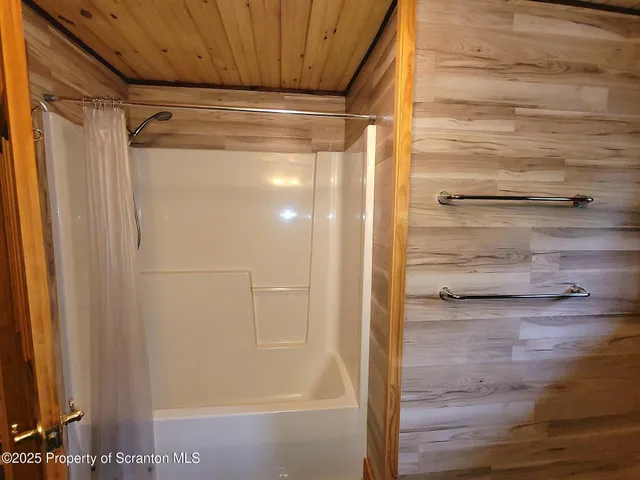 a spacious bedroom with a bed and wooden floor