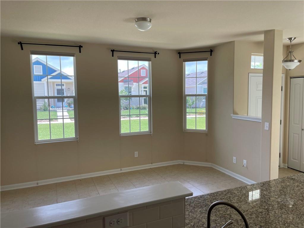 1420 Nevarez Kyle, TX 78640 - Photo 3 of 9 A well-lit interior space features tile flooring and multiple windows, inviting neighborhood views.