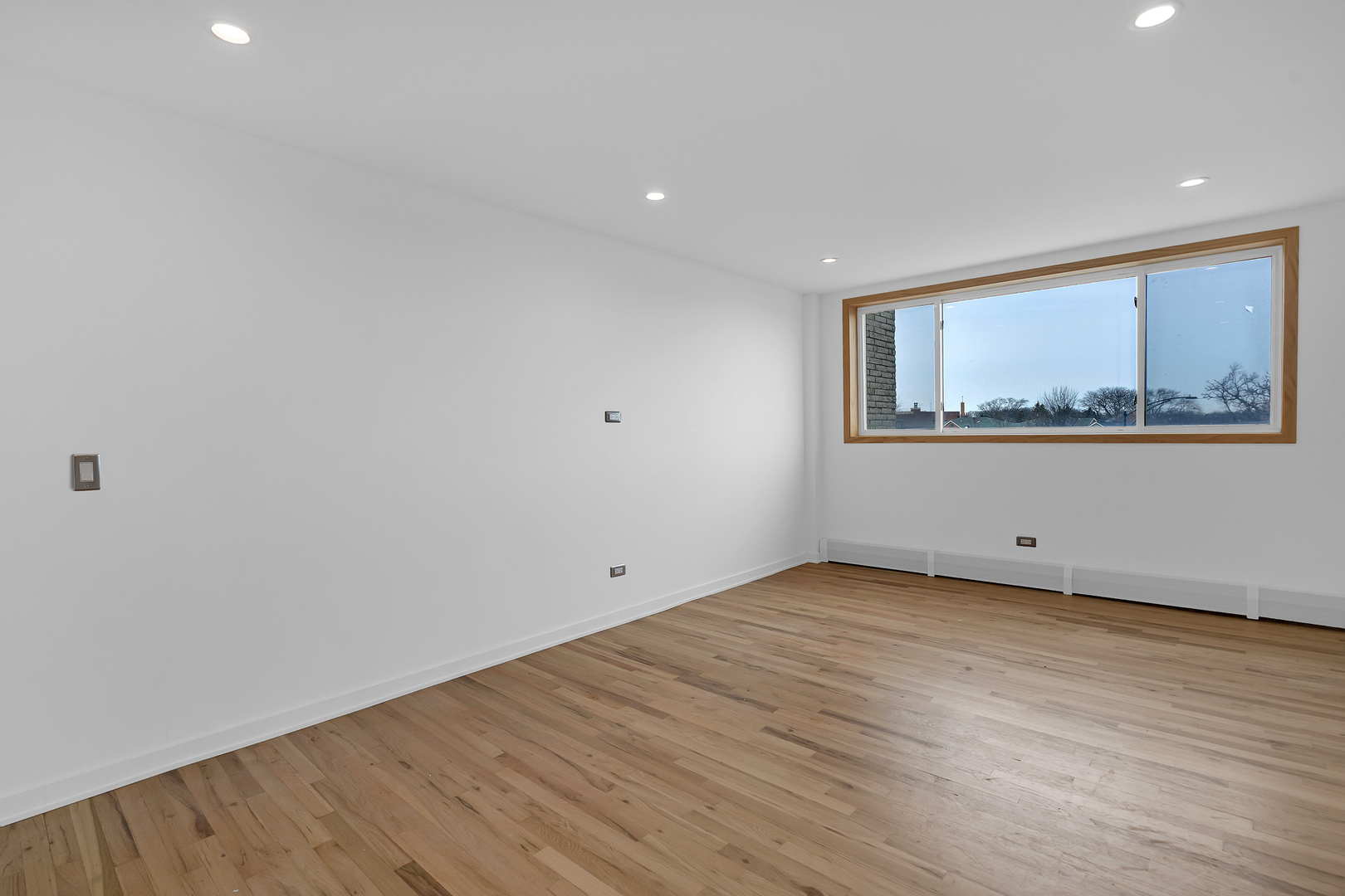 4976 North Milwaukee Avenue, Unit 401 Chicago, IL 60630 - Photo 18 of 23 a view of an empty room with wooden floor and a window