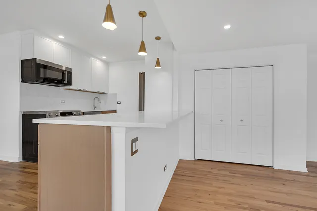 a view of kitchen with stainless steel appliances refrigerator stove microwave and cabinets