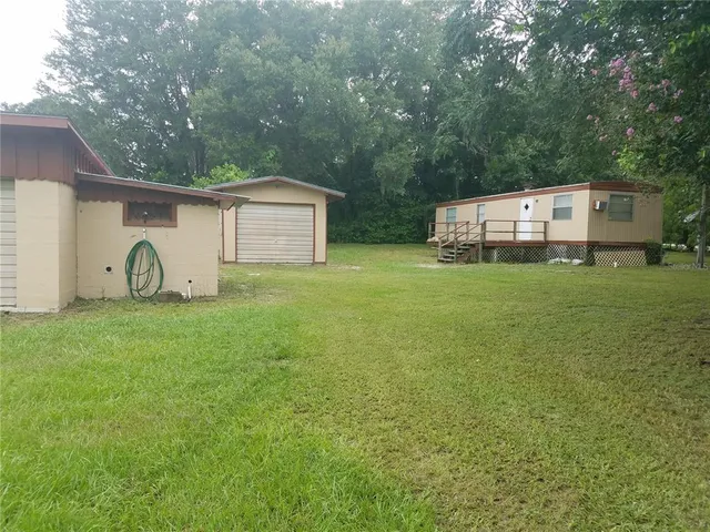 a view of a house with backyard and garden