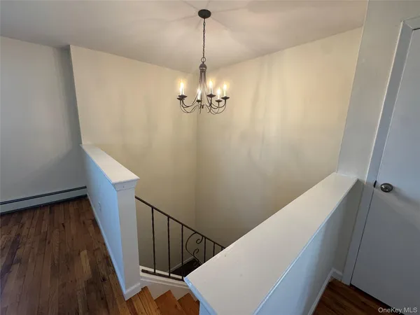 a view of a hallway with windows and chandelier