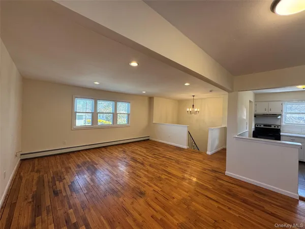 a view of empty room with wooden floor and fireplace