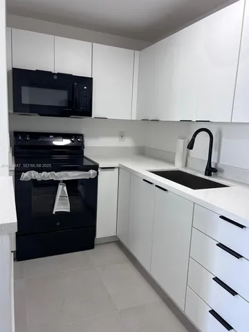a kitchen with granite countertop a stove and a sink
