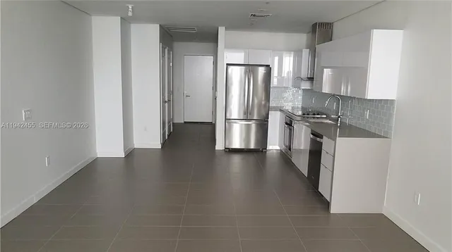 a kitchen with stainless steel appliances a refrigerator and wooden floor
