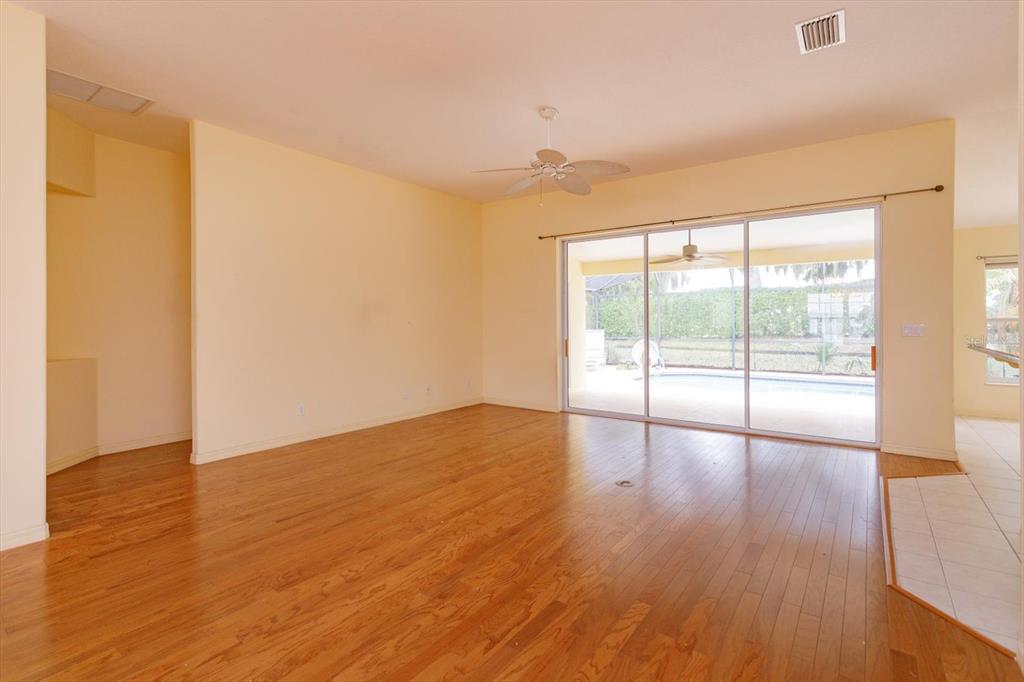 5151 Indian Ocean Loop Tavares, FL 32778 - Photo 12 of 28 a view of an empty room with wooden floor and a window