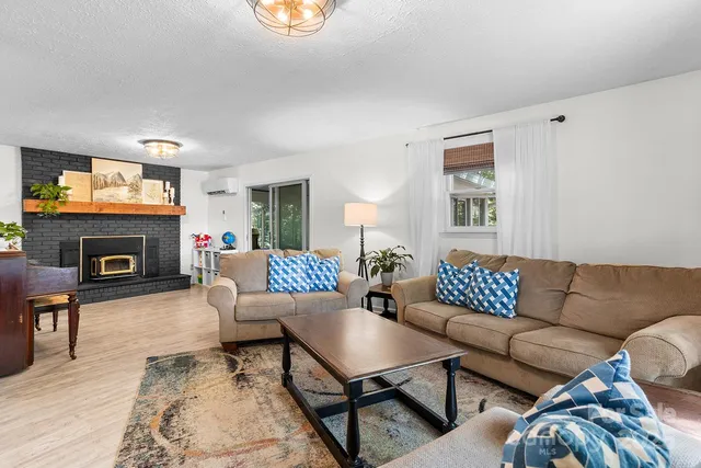 a living room with furniture a fireplace and a flat screen tv