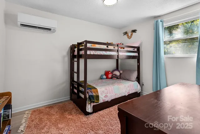 a bedroom with two beds and window