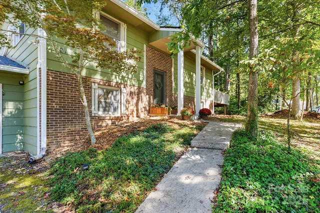 a view of a pathway of house with a yard