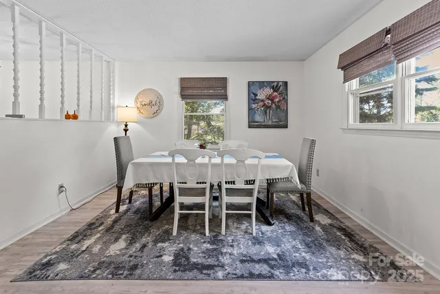 a dining room with wooden floor and window