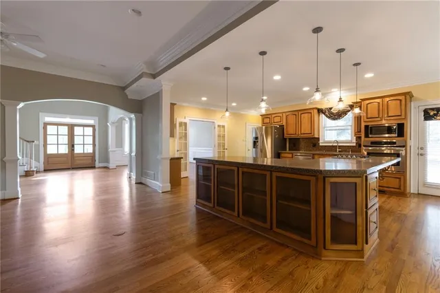 a open kitchen with stainless steel appliances granite countertop a stove and a wooden floors