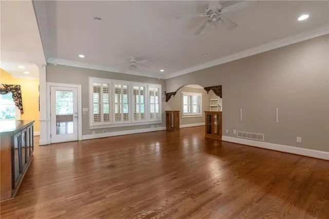 a view of an empty room with wooden floor and a floor to ceiling window