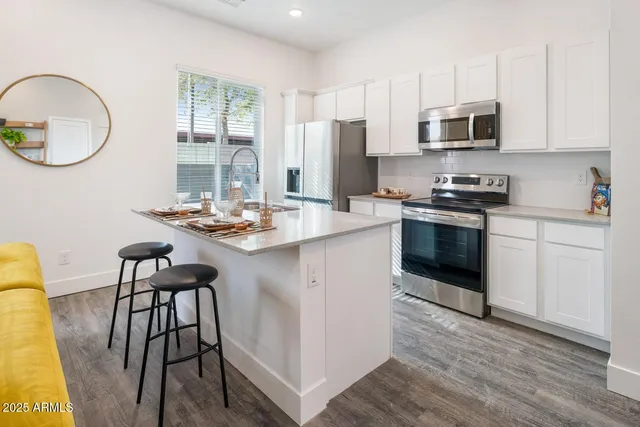 a kitchen with stainless steel appliances granite countertop a stove a microwave a sink a stove and a refrigerator