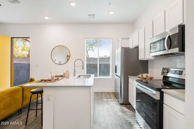 a kitchen with kitchen island granite countertop a sink stove and refrigerator
