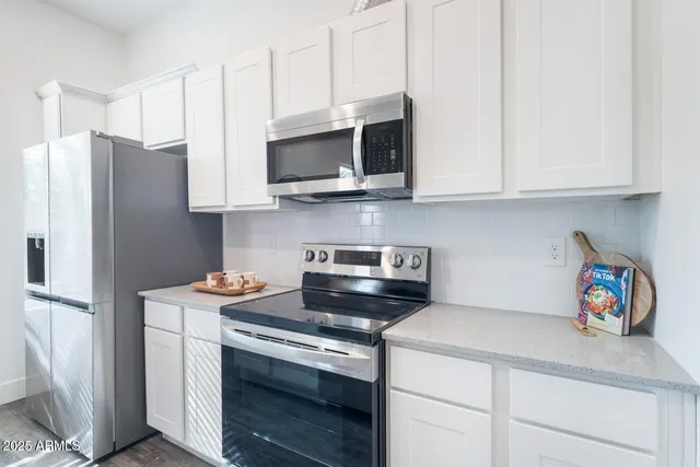 a kitchen with stainless steel appliances granite countertop white cabinets sink and a stainless steel appliances