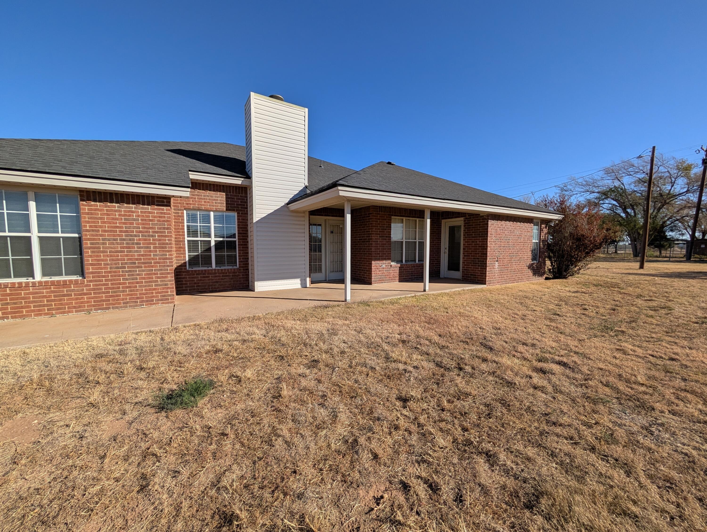 8909 19th Street Lubbock, TX 79407 - Photo 1 of 13 a front view of a house with a yard