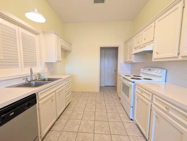 a kitchen with a sink cabinets and a window