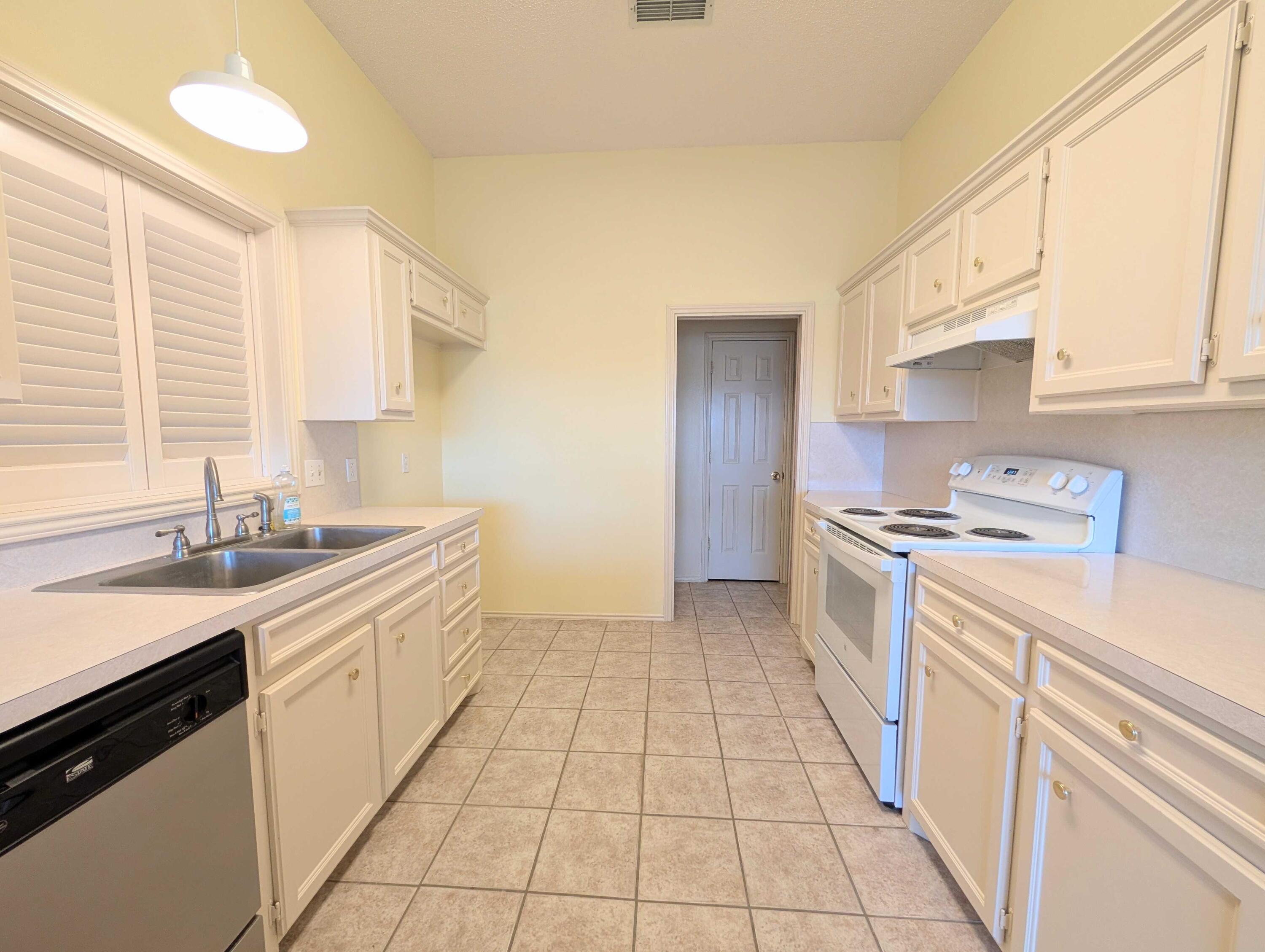 8909 19th Street Lubbock, TX 79407 - Photo 11 of 13 a kitchen with a sink cabinets and a window