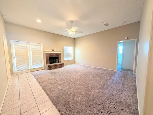 en empty room with windows and fireplace