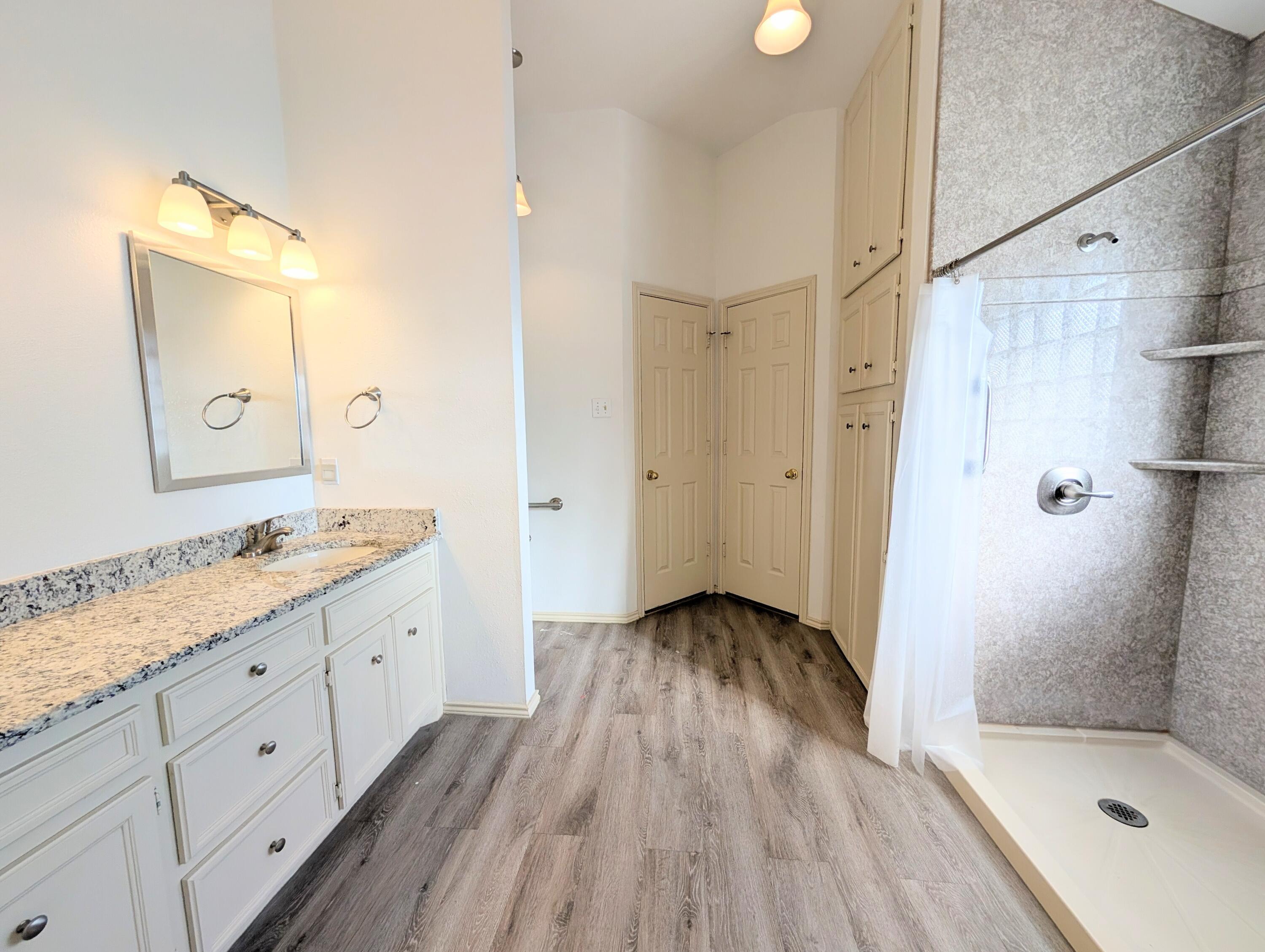 8909 19th Street Lubbock, TX 79407 - Photo 5 of 13 a bathroom with a sink a toilet and shower