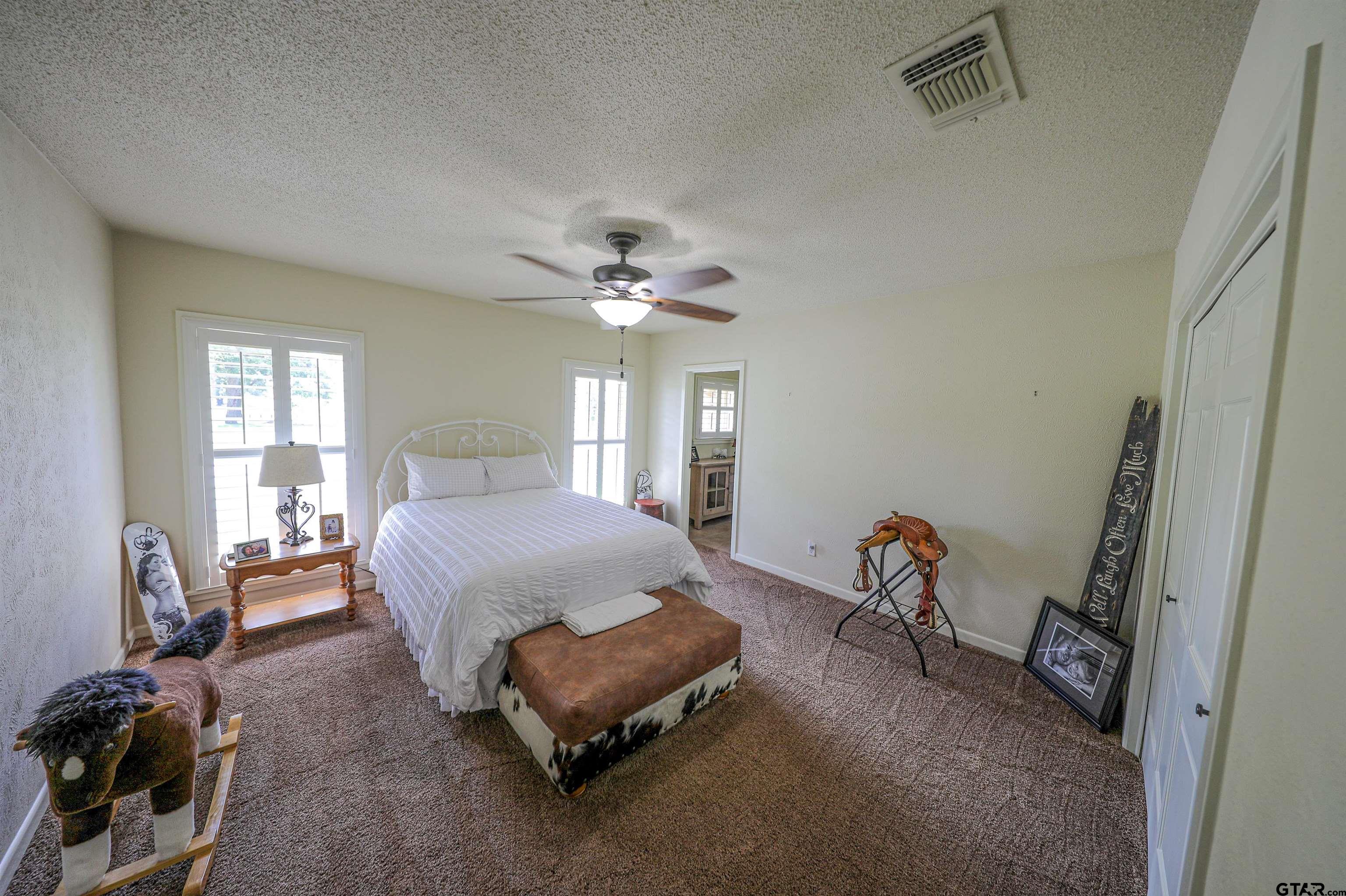 2125 Highway 11 Pittsburg, TX 75686 - Photo 11 of 27 a spacious bedroom with a bed a chandelier and dresser