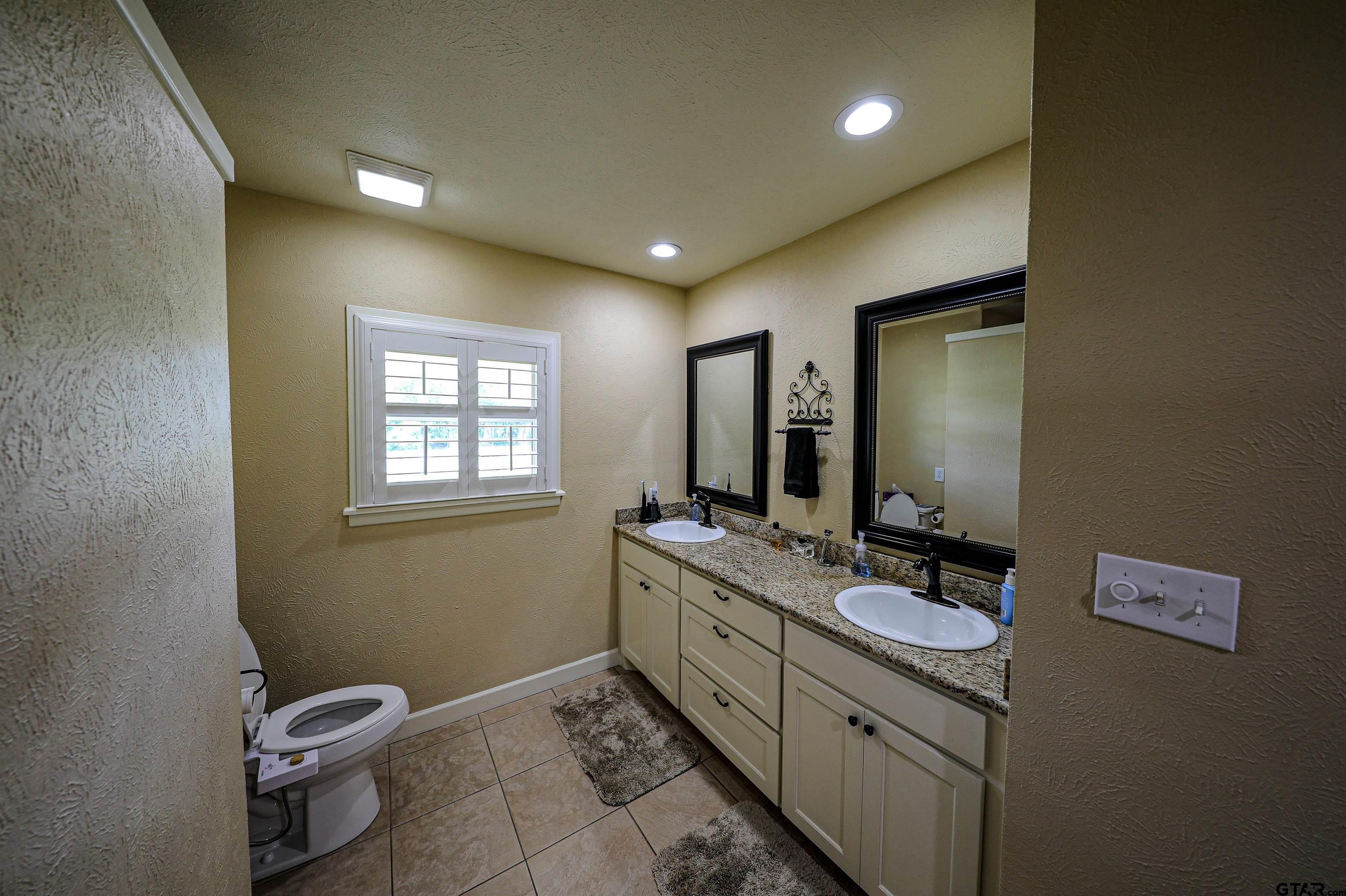 2125 Highway 11 Pittsburg, TX 75686 - Photo 16 of 27 a bathroom with a double vanity sink toilet and mirror