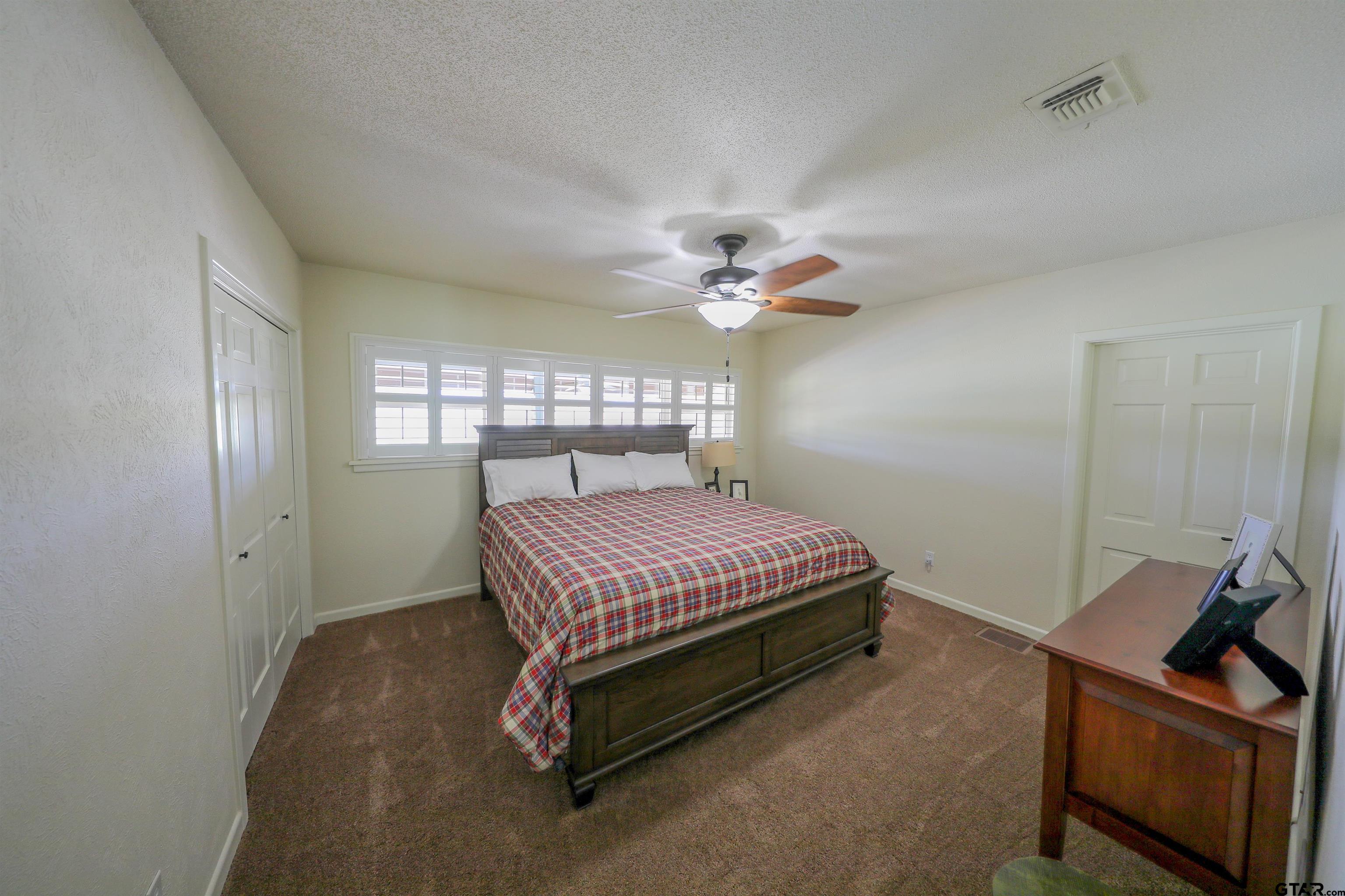 2125 Highway 11 Pittsburg, TX 75686 - Photo 18 of 27 a bedroom with a bed and a chandelier