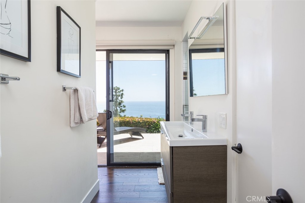 1401 Emerald Bay Laguna Beach, CA 92651 - Photo 17 of 28 a en suite bathroom with a sink a mirror and next to a window