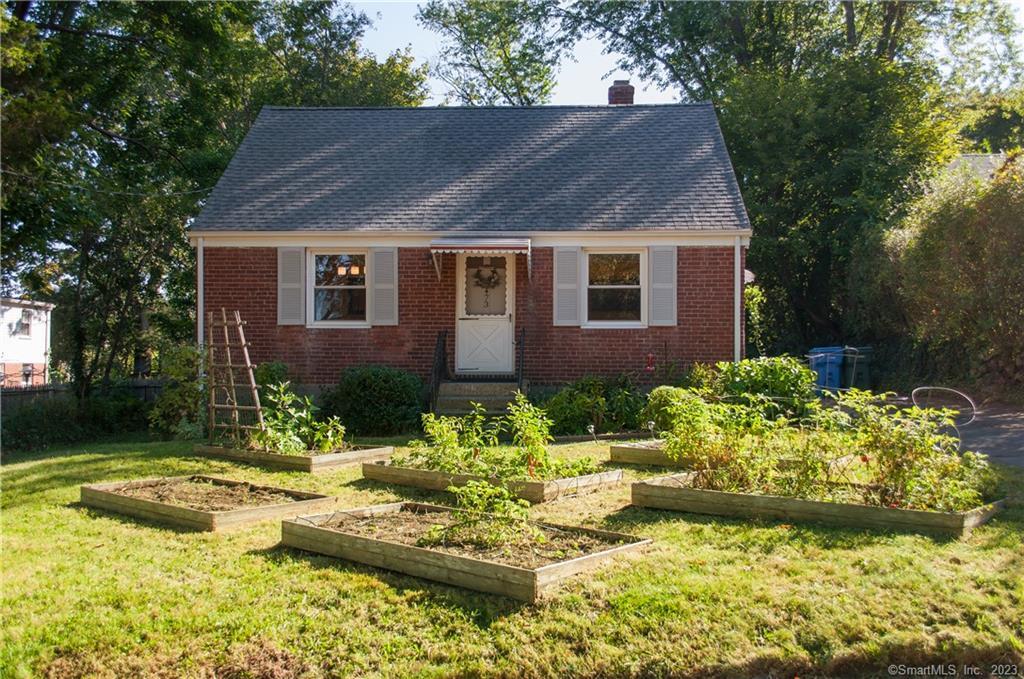 a front view of a house with a yard and a garden