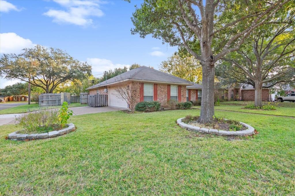 a front view of a house with a garden and trees