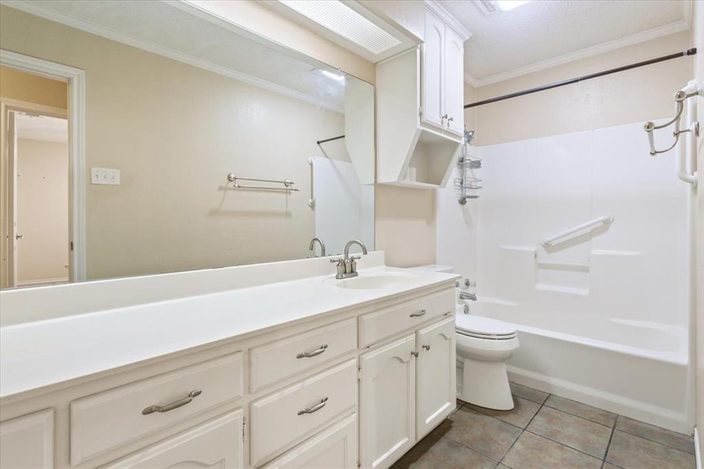 10700 Apache Drive Waco, TX 76712 - Photo 11 of 15 a bathroom with a granite countertop sink a toilet and a bathtub