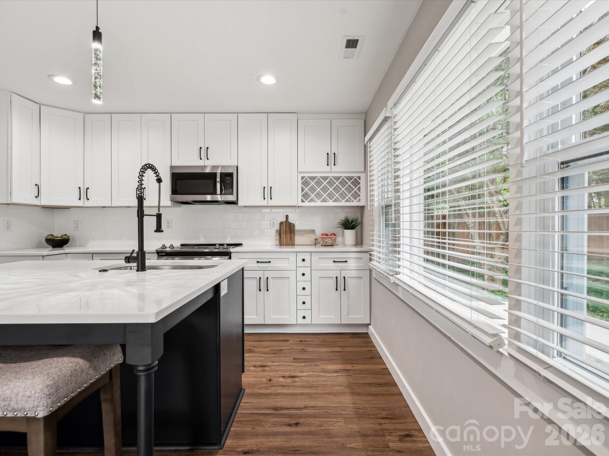 2000 Tyvola Road Charlotte, NC 28210 - Photo 14 of 32 a kitchen with kitchen island granite countertop a sink stove and cabinets