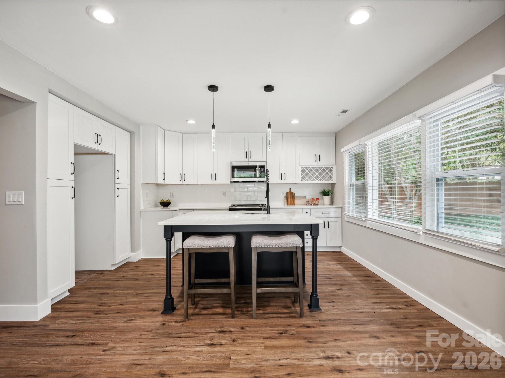 2000 Tyvola Road Charlotte, NC 28210 - Photo 15 of 32 a kitchen with kitchen island a dining table chairs and a refrigerator