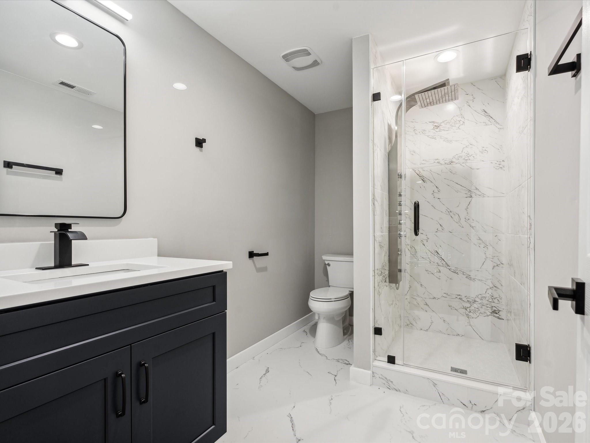 2000 Tyvola Road Charlotte, NC 28210 - Photo 22 of 32 a bathroom with a sink a toilet and shower