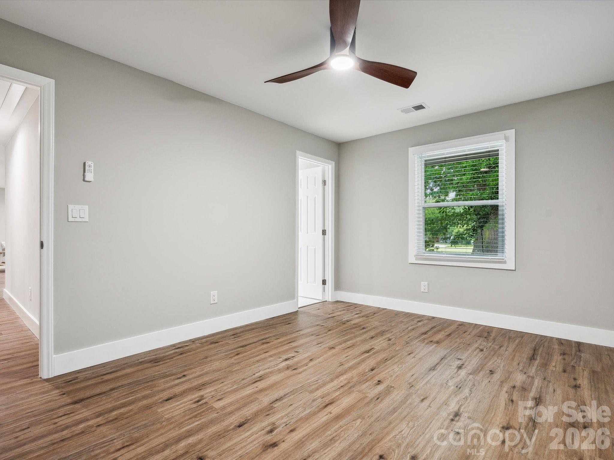 2000 Tyvola Road Charlotte, NC 28210 - Photo 27 of 32 a view of an empty room with wooden floor and a window