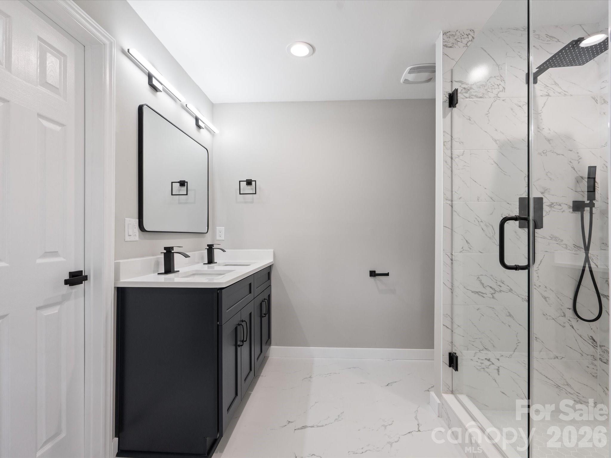 2000 Tyvola Road Charlotte, NC 28210 - Photo 28 of 32 a bathroom with a double vanity sink a mirror and shower