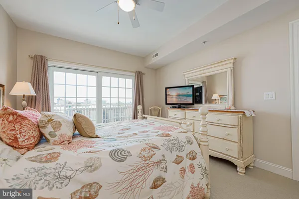 a bedroom with a large bed and a flat tv screen