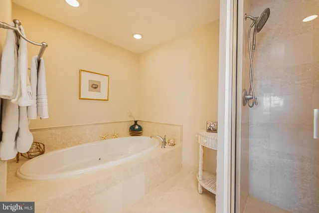 a white bath tub sitting next to a white sink and vanity