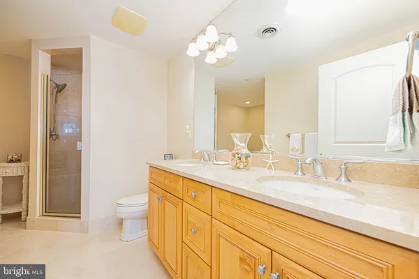 a bathroom with a granite countertop sink a toilet and a mirror