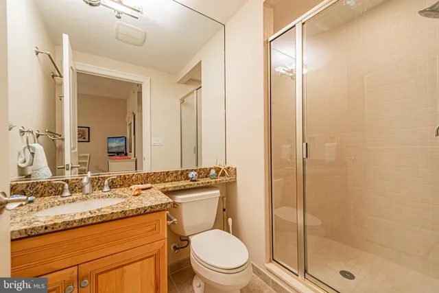 a bathroom with a granite countertop sink toilet and shower