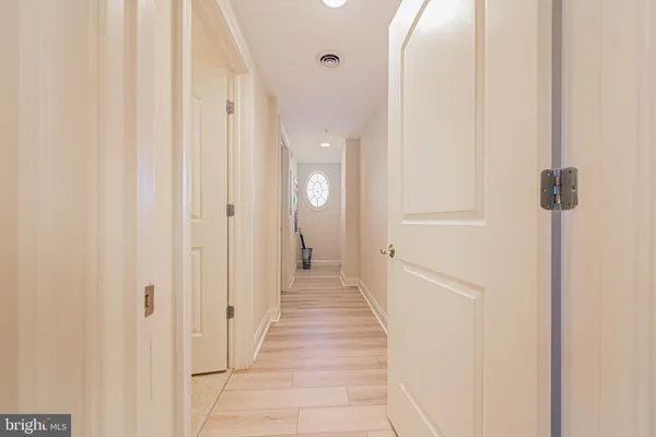 a view of a hallway with wooden floor and staircase