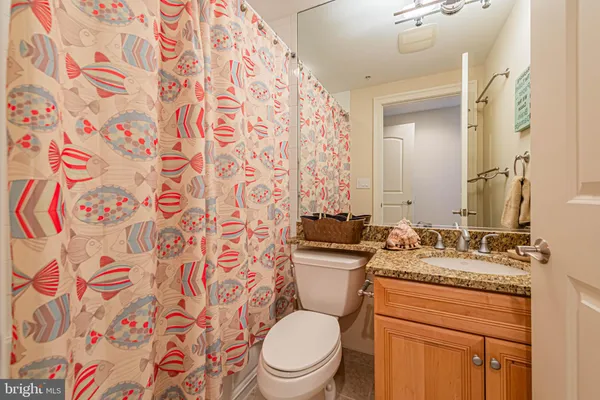 a bathroom with a granite countertop toilet sink and mirror
