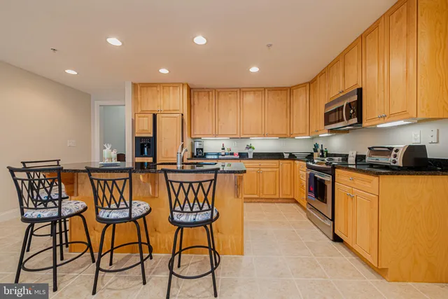 a kitchen with stainless steel appliances granite countertop wooden cabinets a stove a sink and a granite counter tops